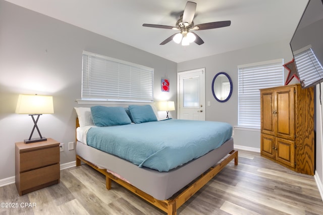 bedroom featuring light wood-type flooring, ceiling fan, and baseboards