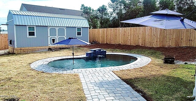 view of pool with an outbuilding and a lawn