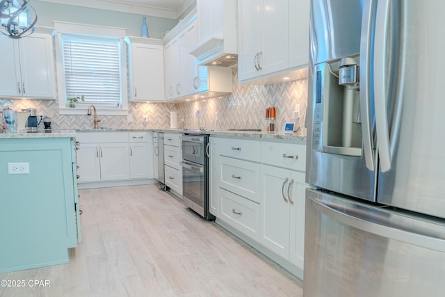 kitchen with white cabinetry, backsplash, stainless steel fridge, and custom range hood