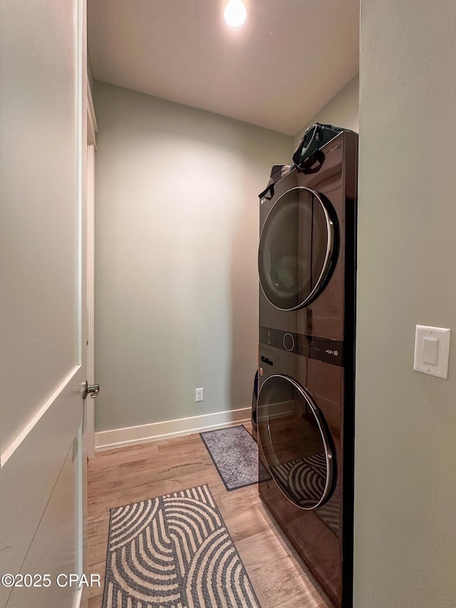 washroom featuring stacked washer / drying machine and light hardwood / wood-style floors