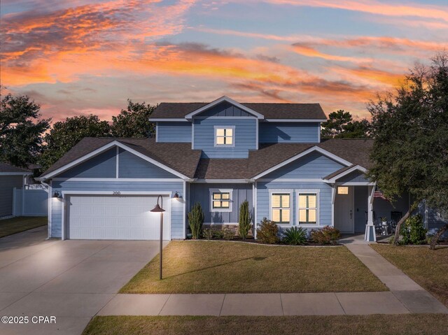 view of front of property with a garage and a yard