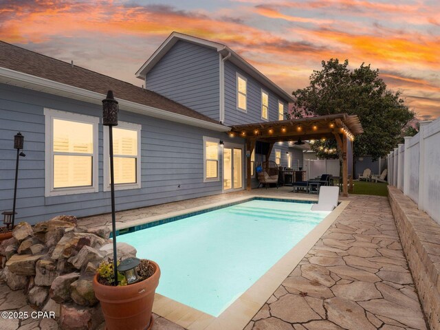 pool at dusk featuring a patio