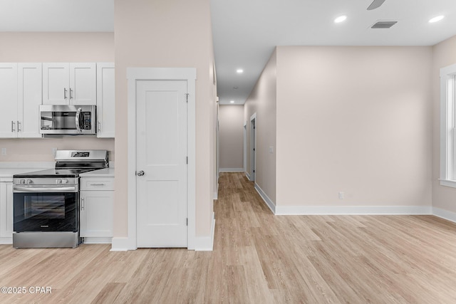 kitchen with white cabinetry, light hardwood / wood-style flooring, and appliances with stainless steel finishes