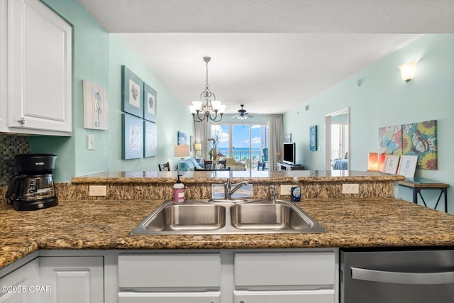 kitchen featuring ceiling fan with notable chandelier, pendant lighting, dishwasher, white cabinetry, and sink