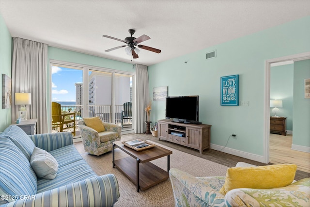 living room with ceiling fan and light hardwood / wood-style floors