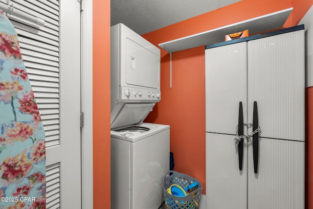 laundry room with a textured ceiling and stacked washer and clothes dryer