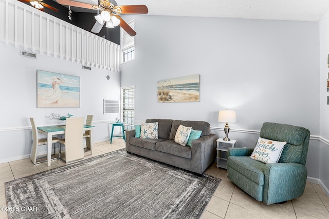 tiled living room featuring ceiling fan and high vaulted ceiling