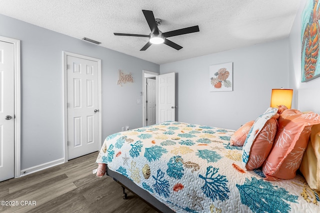 bedroom featuring wood-type flooring, a textured ceiling, and ceiling fan