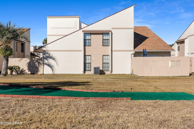 back of house featuring a yard and central air condition unit