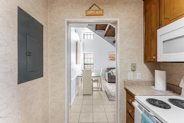 kitchen with light tile patterned flooring, white appliances, and electric panel