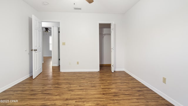 unfurnished bedroom featuring dark wood-type flooring, ceiling fan, and a closet