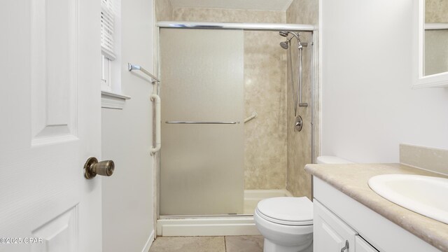 bathroom with vanity, walk in shower, tile patterned floors, and toilet