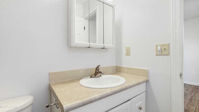 bathroom featuring vanity, hardwood / wood-style floors, and toilet