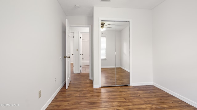 unfurnished bedroom featuring dark hardwood / wood-style floors and a closet