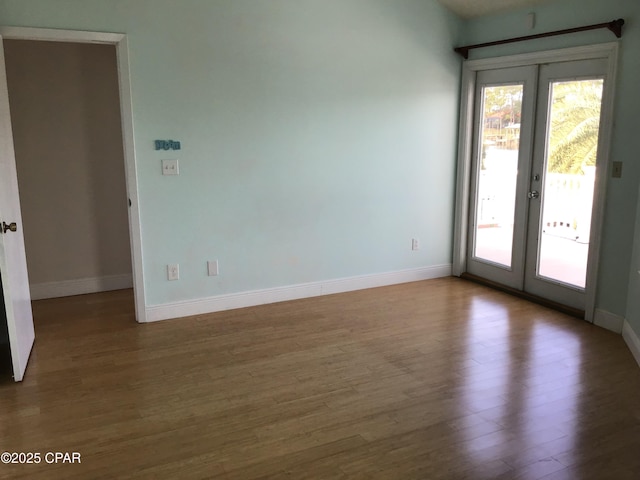 unfurnished room with hardwood / wood-style flooring and french doors