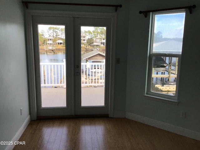 doorway featuring a water view, french doors, and hardwood / wood-style flooring