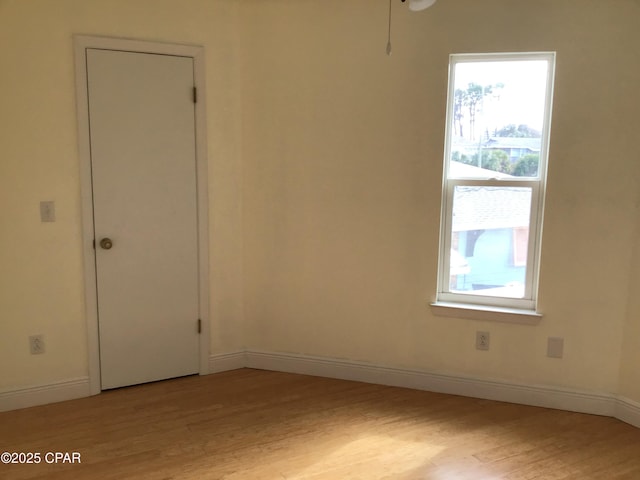 spare room featuring light wood-type flooring and a healthy amount of sunlight