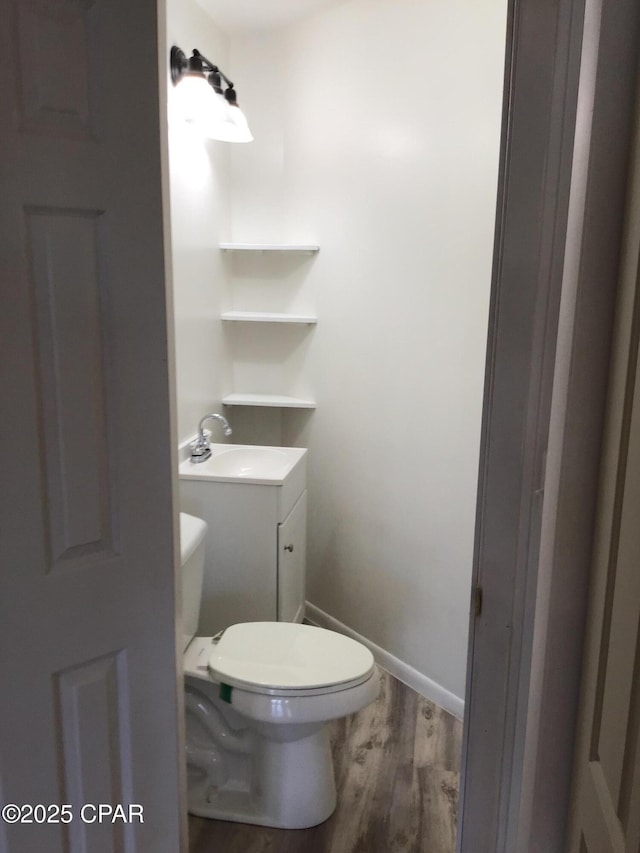 bathroom featuring toilet, vanity, and hardwood / wood-style flooring