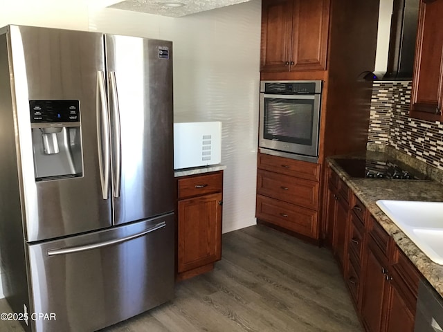 kitchen with light stone countertops, appliances with stainless steel finishes, dark hardwood / wood-style flooring, tasteful backsplash, and sink