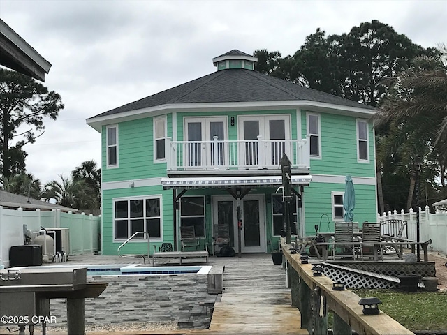 rear view of property featuring a balcony, a pool side deck, french doors, and a patio