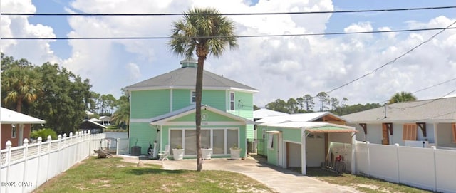 rear view of house featuring central AC and a yard