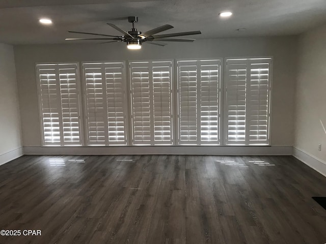 empty room featuring dark wood-type flooring and ceiling fan