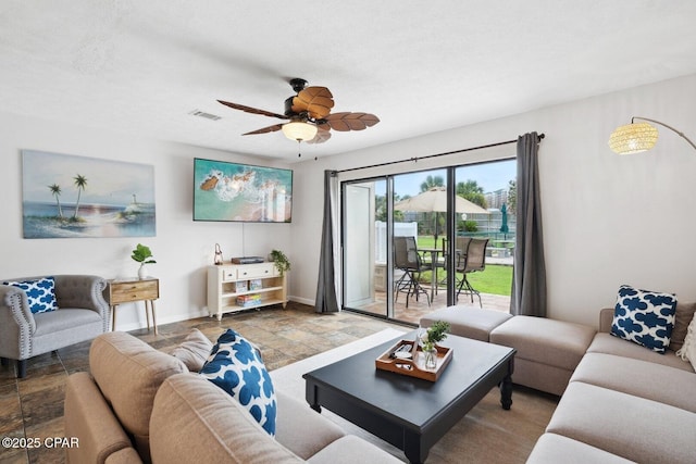 living room featuring ceiling fan and a textured ceiling