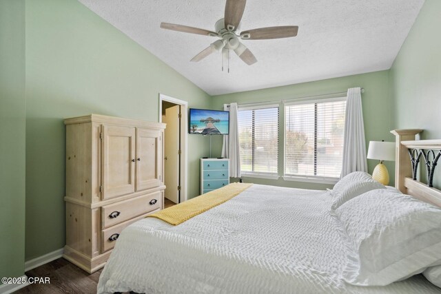 bedroom with a textured ceiling, ceiling fan, vaulted ceiling, and dark hardwood / wood-style floors