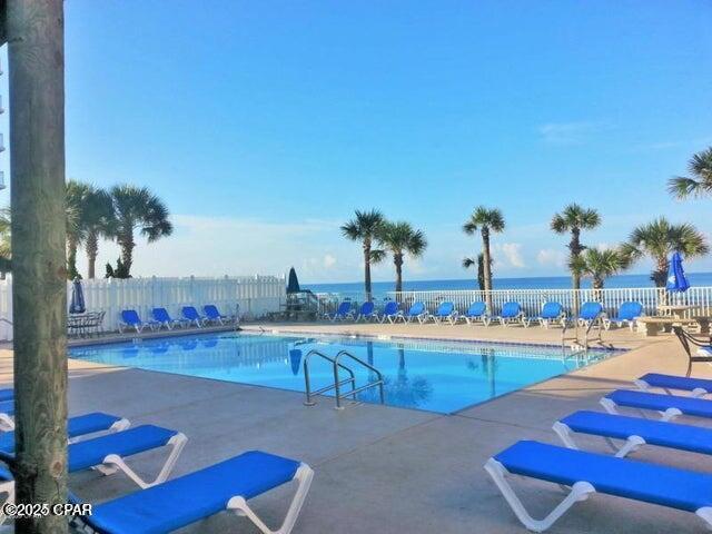 view of swimming pool with a patio area and a water view