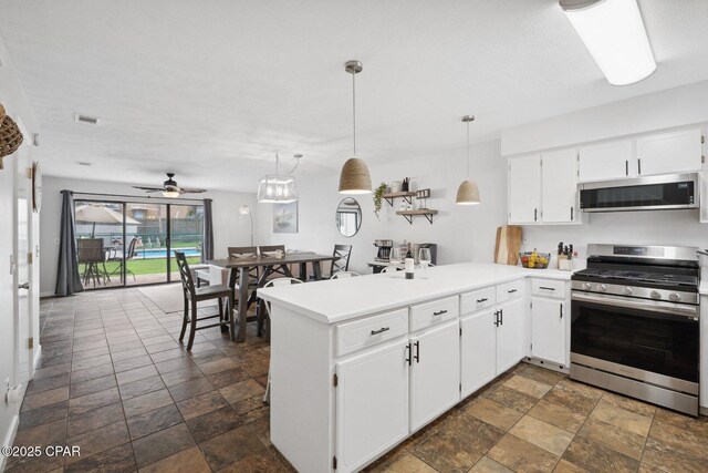 kitchen with decorative light fixtures, stainless steel appliances, kitchen peninsula, and white cabinets