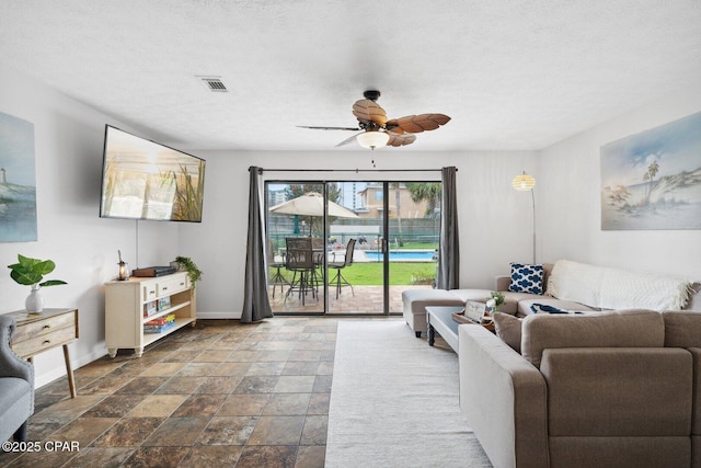 living room with a textured ceiling and ceiling fan