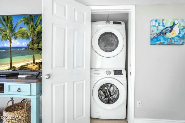 clothes washing area with stacked washing maching and dryer