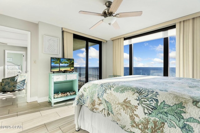 bedroom featuring ceiling fan, a wall of windows, and access to exterior