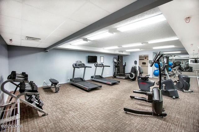 exercise room with a paneled ceiling and carpet flooring