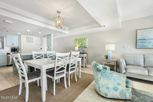 dining room with a raised ceiling and an inviting chandelier