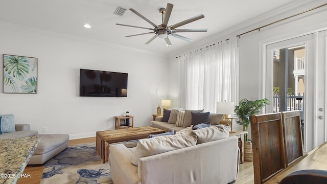 living room featuring crown molding and light hardwood / wood-style flooring