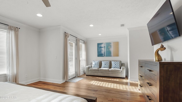 bedroom with ornamental molding, ceiling fan, a textured ceiling, and light hardwood / wood-style floors