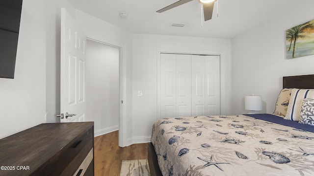 bedroom with dark wood-type flooring, a closet, and ceiling fan