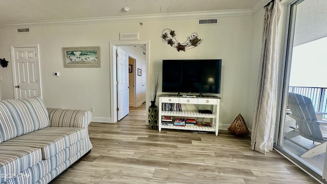 living room featuring light hardwood / wood-style floors, a textured ceiling, and crown molding