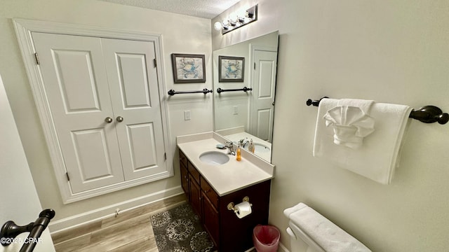 bathroom featuring vanity, wood-type flooring, and a textured ceiling