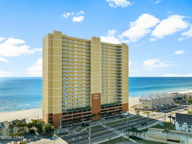 view of building exterior featuring a water view and a view of the beach