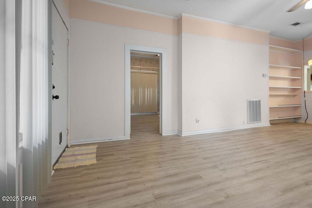 empty room with ceiling fan and light hardwood / wood-style flooring