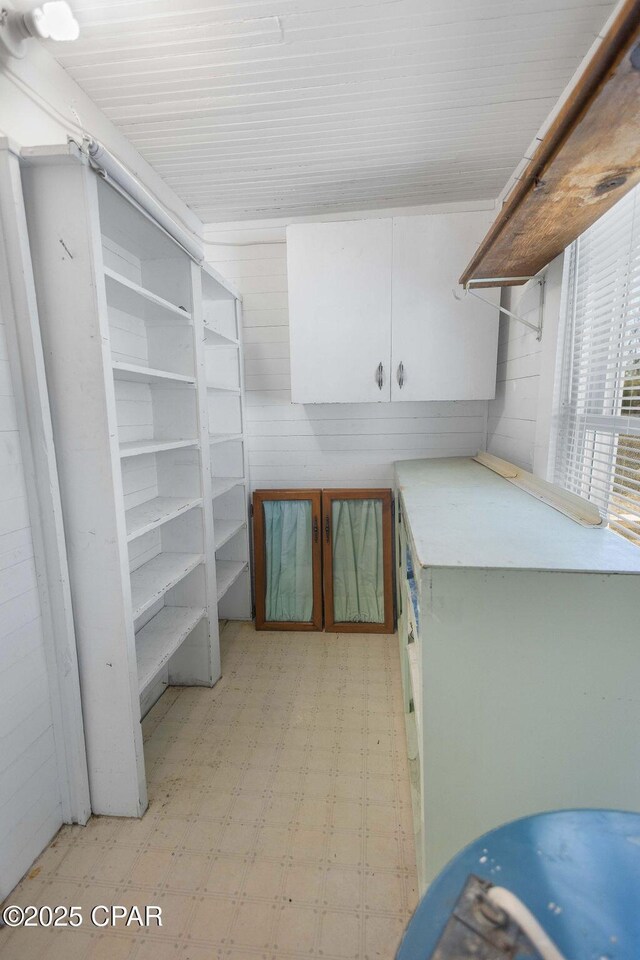 washroom with water heater and wooden walls