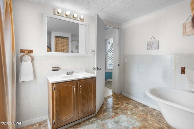 bathroom with a textured ceiling, tile walls, and vanity