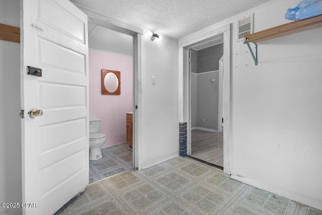 bathroom with toilet, vanity, and a textured ceiling