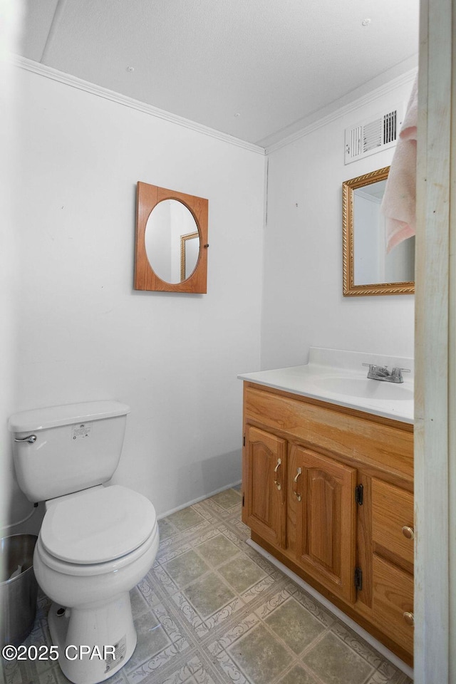 half bathroom featuring toilet, vanity, crown molding, and visible vents