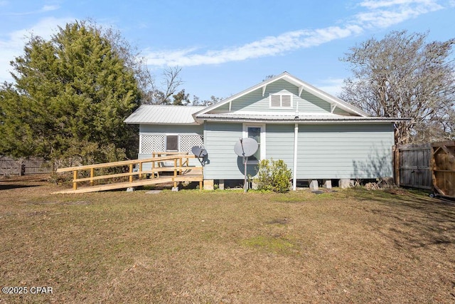 back of property with a deck and a lawn