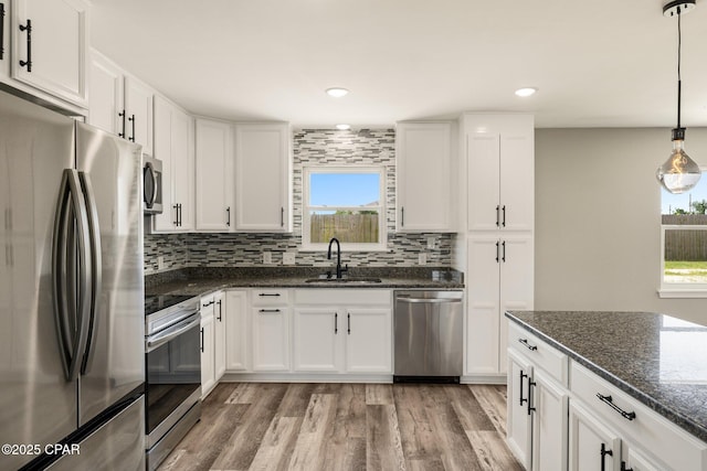 kitchen with stainless steel appliances, tasteful backsplash, plenty of natural light, and a sink