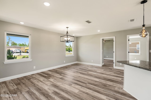 unfurnished dining area featuring recessed lighting, visible vents, baseboards, and wood finished floors