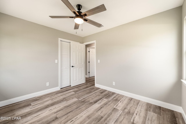 unfurnished room featuring light wood finished floors, ceiling fan, and baseboards